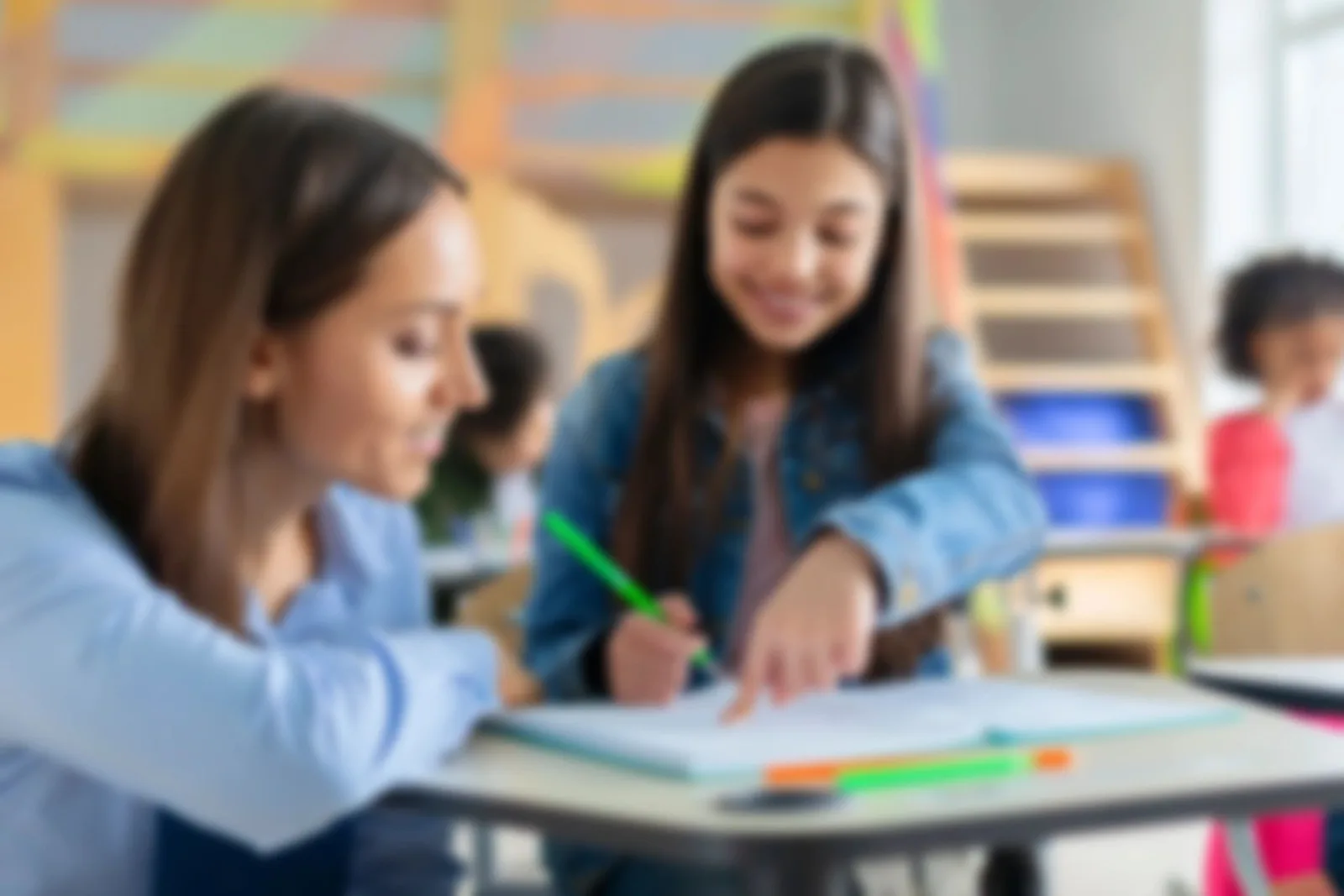 A teacher helping a student with her schoolwork